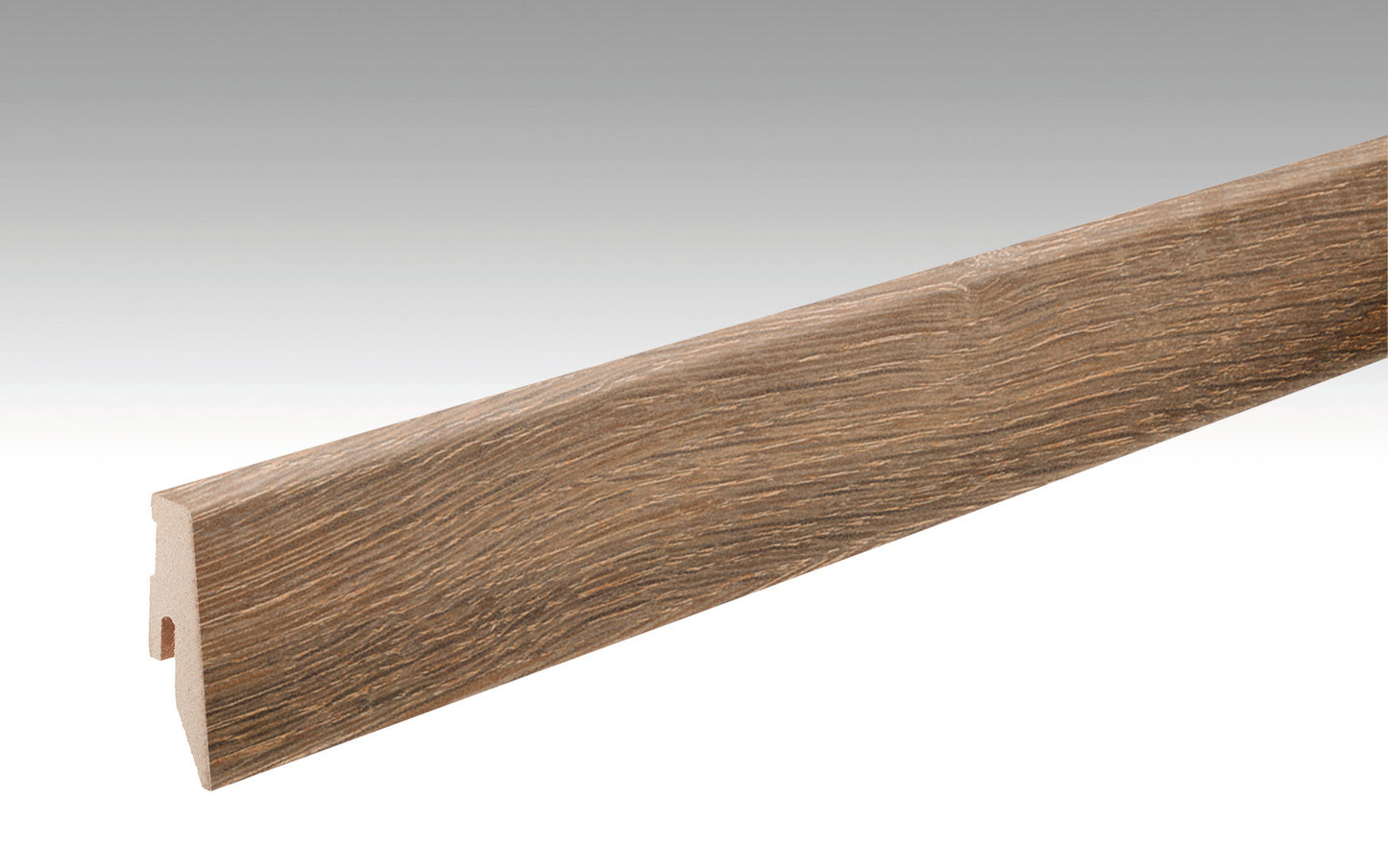 Lange, rechteckige Fußleiste aus Holzwerkstoff mit sichtbarer Maserung in Eichenoptik. Oberfläche leicht strukturiert und matt, in einem braunen Farbton.