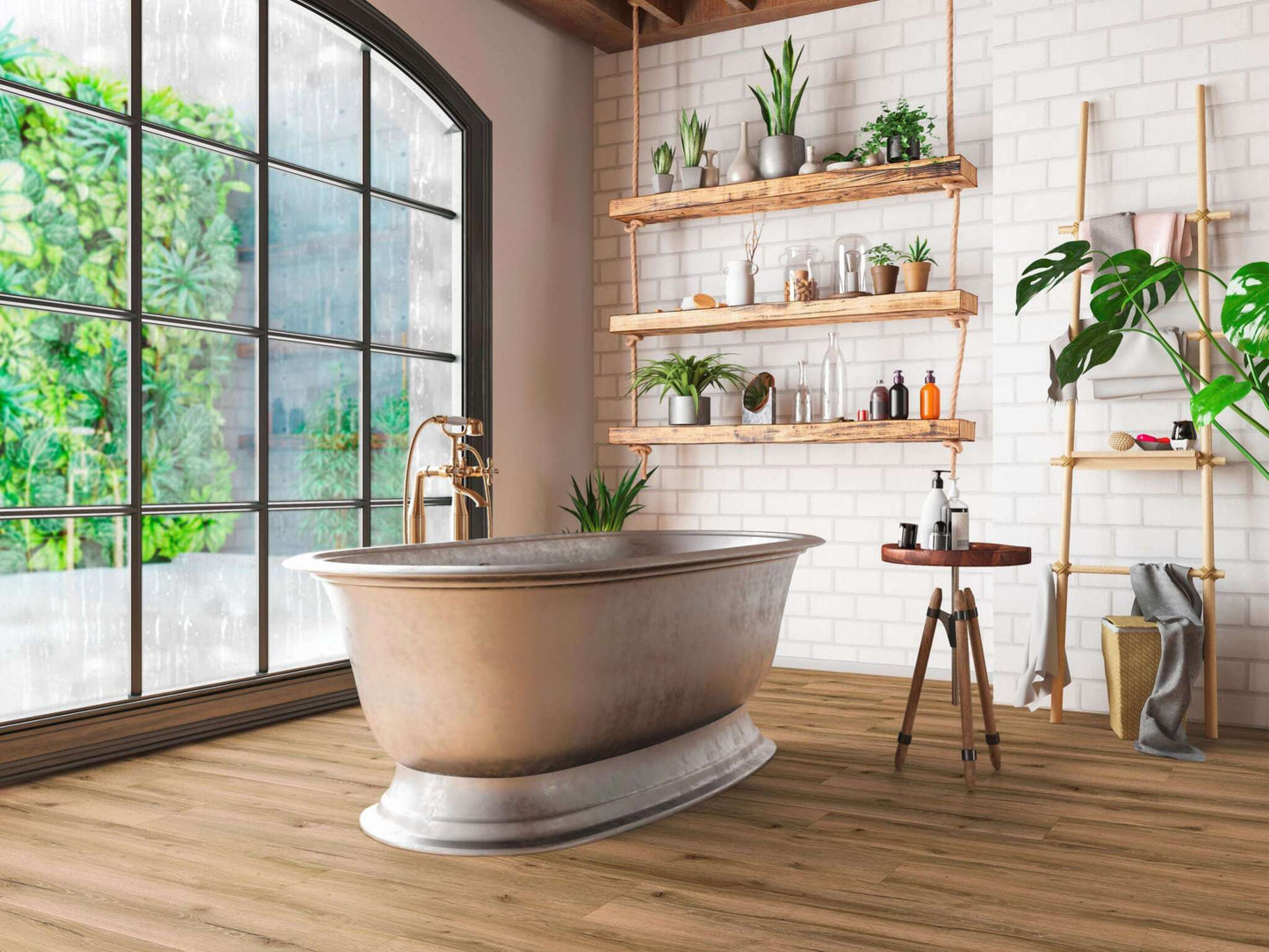 Freistehende Badewanne mit Goldarmatur, große Fensterfront mit Blick auf grüne Pflanzenwand, Holzregale mit Pflanzen, Flaschen, Kosmetik, kleiner Beistelltisch mit Seifenspendern, Leiter mit Handtüchern, Korb und Monstera-Pflanze, weiß gemauerte Wand, Holzboden.