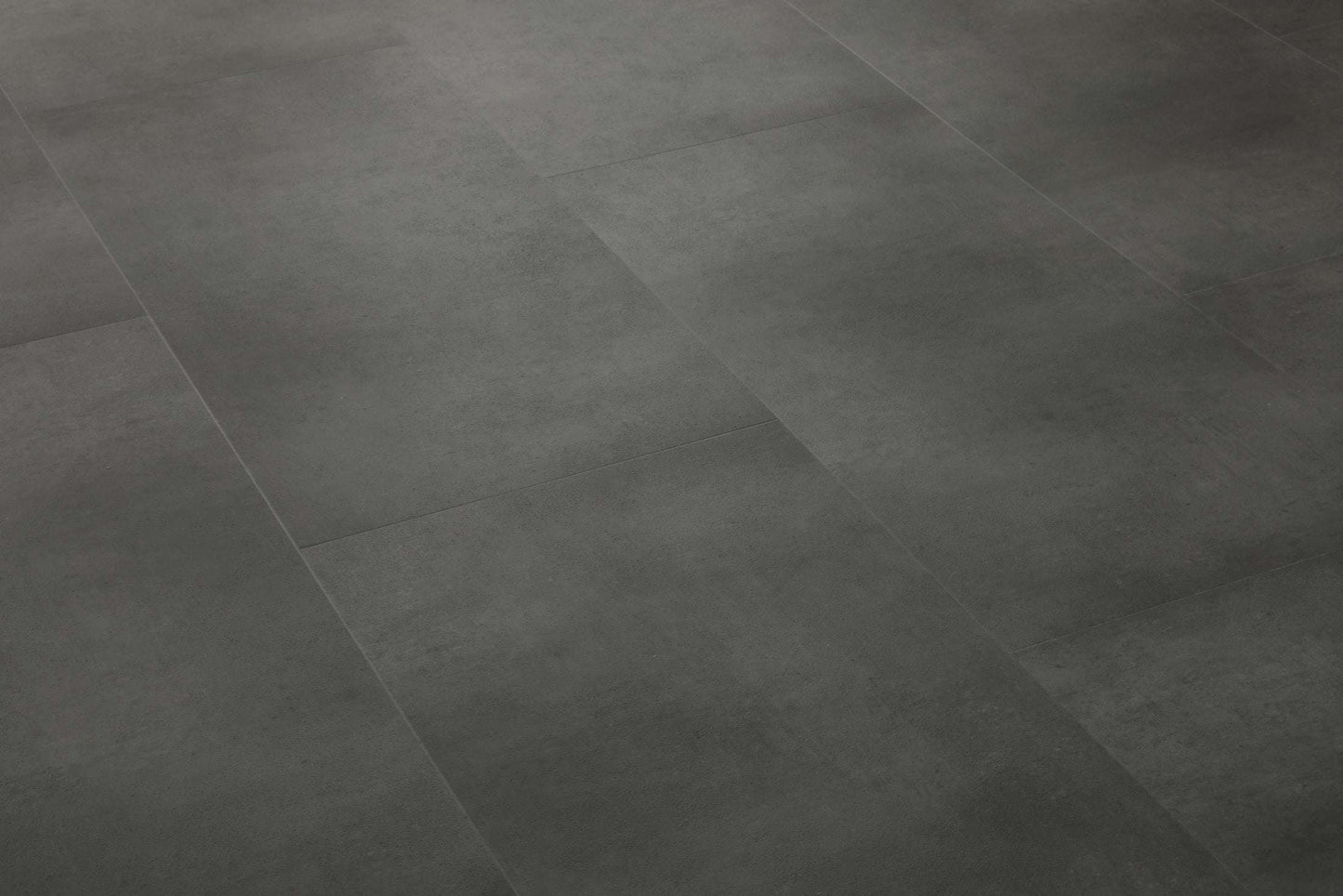 Dunkle, rechteckige Bodenfliesen mit leicht strukturierter Oberfläche und dezentem, industriellem Beton-Look erkennbar.
