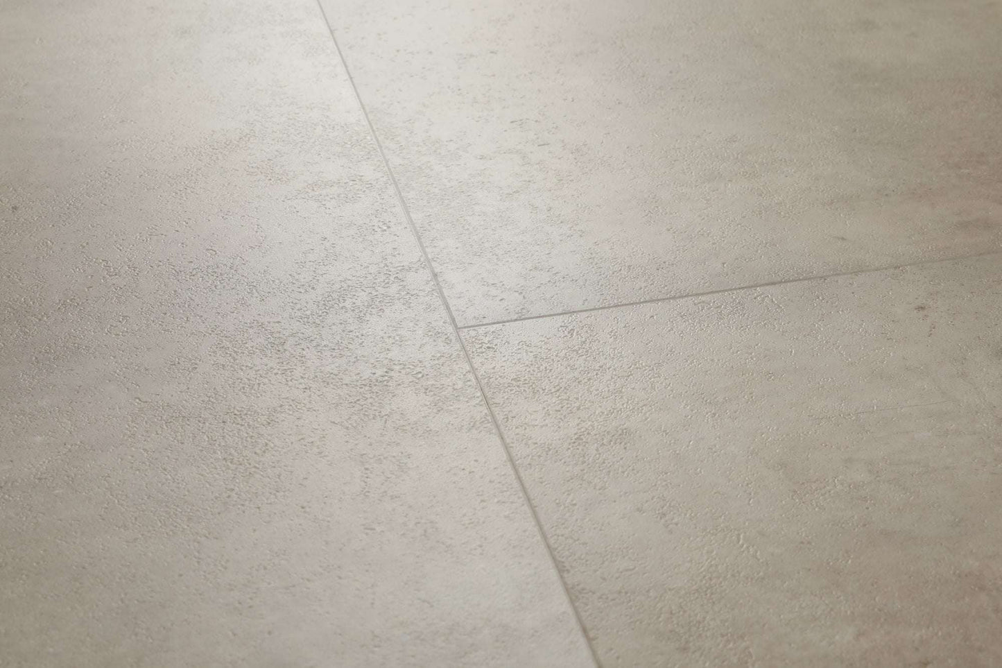 Zwei große, matte, graubeige Bodenfliesen mit feiner, natürlicher Oberflächenstruktur und leicht sichtbaren Fugen.