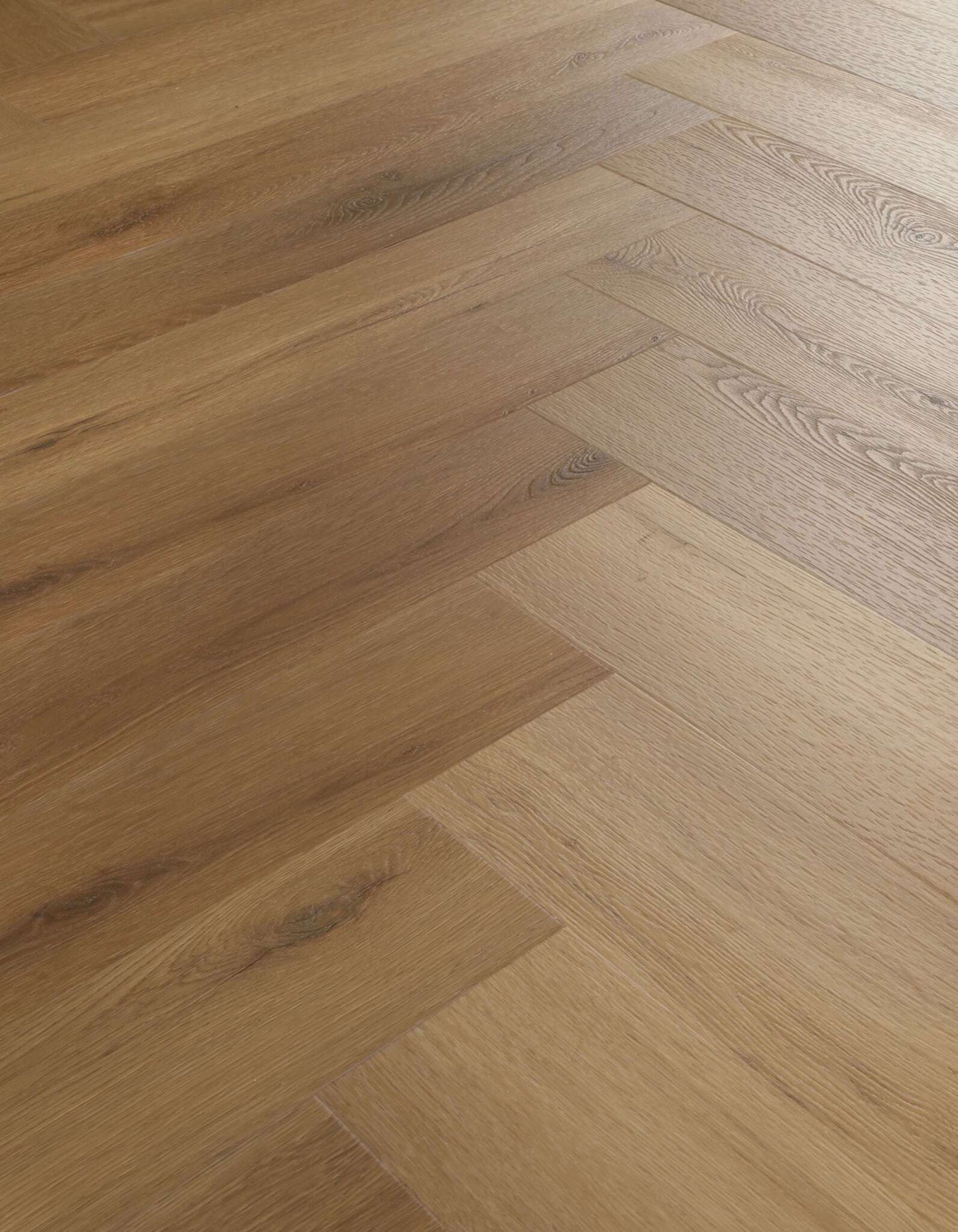 Mehrere rechteckige Holzdielen in warmen Brauntönen liegen im Fischgrätmuster nebeneinander, sichtbare Holzmaserung.