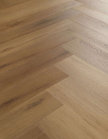 Mehrere rechteckige Holzdielen in warmen Brauntönen liegen im Fischgrätmuster nebeneinander, sichtbare Holzmaserung.