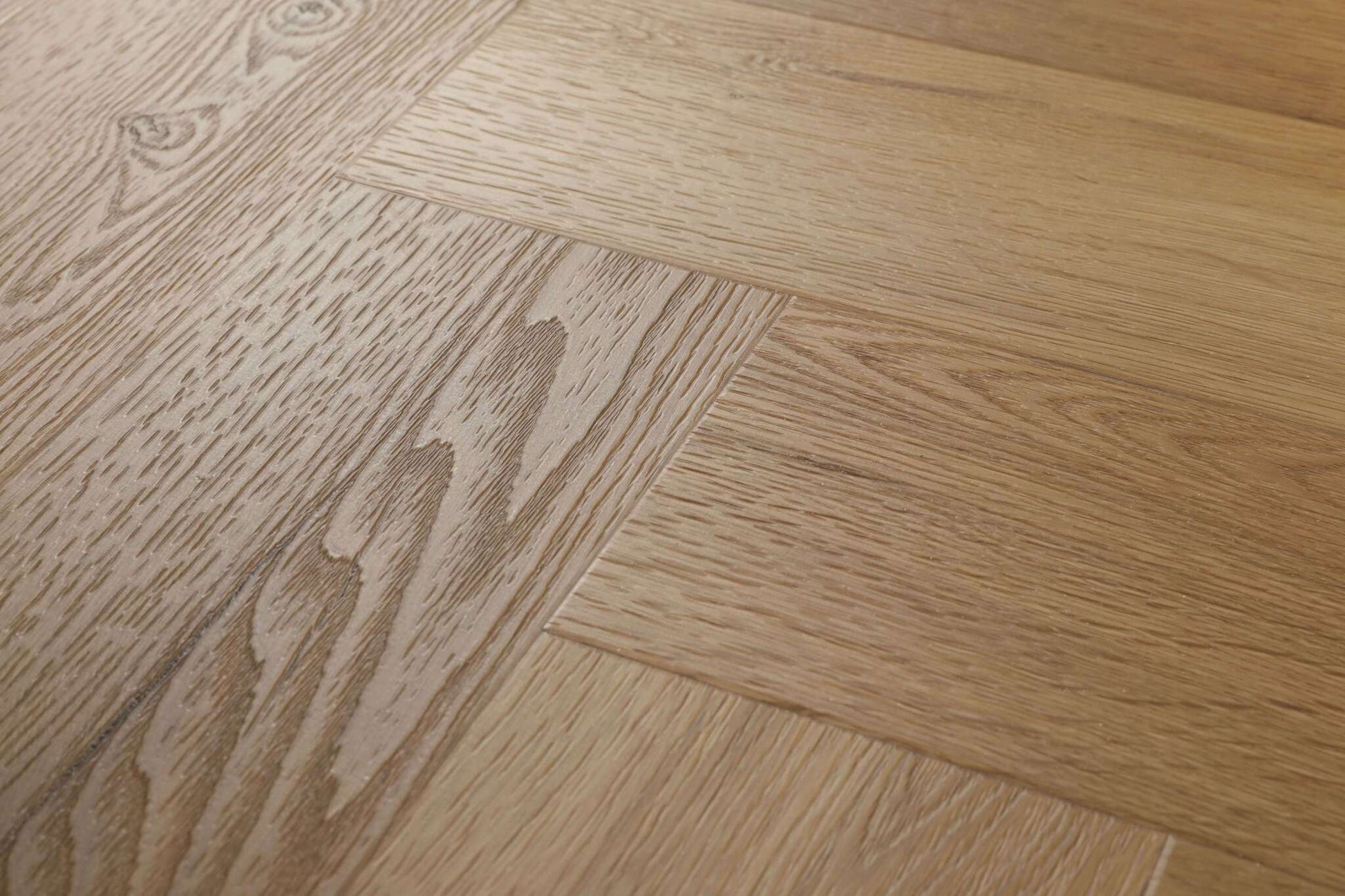 Mehrere Holzbretter in hellem Braunton, unterschiedlich gemasert, eckig verlegt, feine Holzstruktur, ruhige Oberfläche.