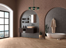 Modernes Badezimmer mit freistehender Badewanne, Waschtisch mit Aufsatzwaschbecken, Spiegel, Regalen, Kaktus, Bademantel und Hausschuhen. Heller Holzboden, Ziegelwand, großes Fenster, Deckenlampe und elegante Dekoration.