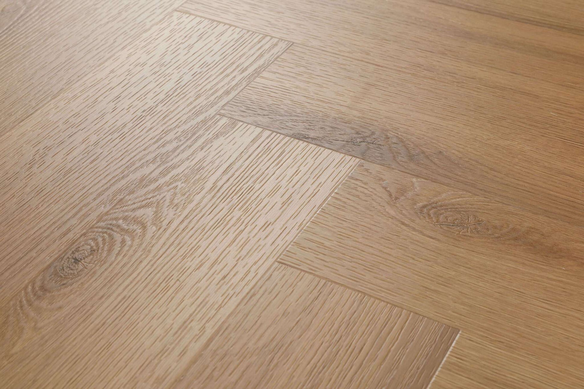 Mehrere Holzdielen mit natürlicher Maserung und sichtbaren Ästen sind in einem Fischgrätmuster eng aneinander verlegt.