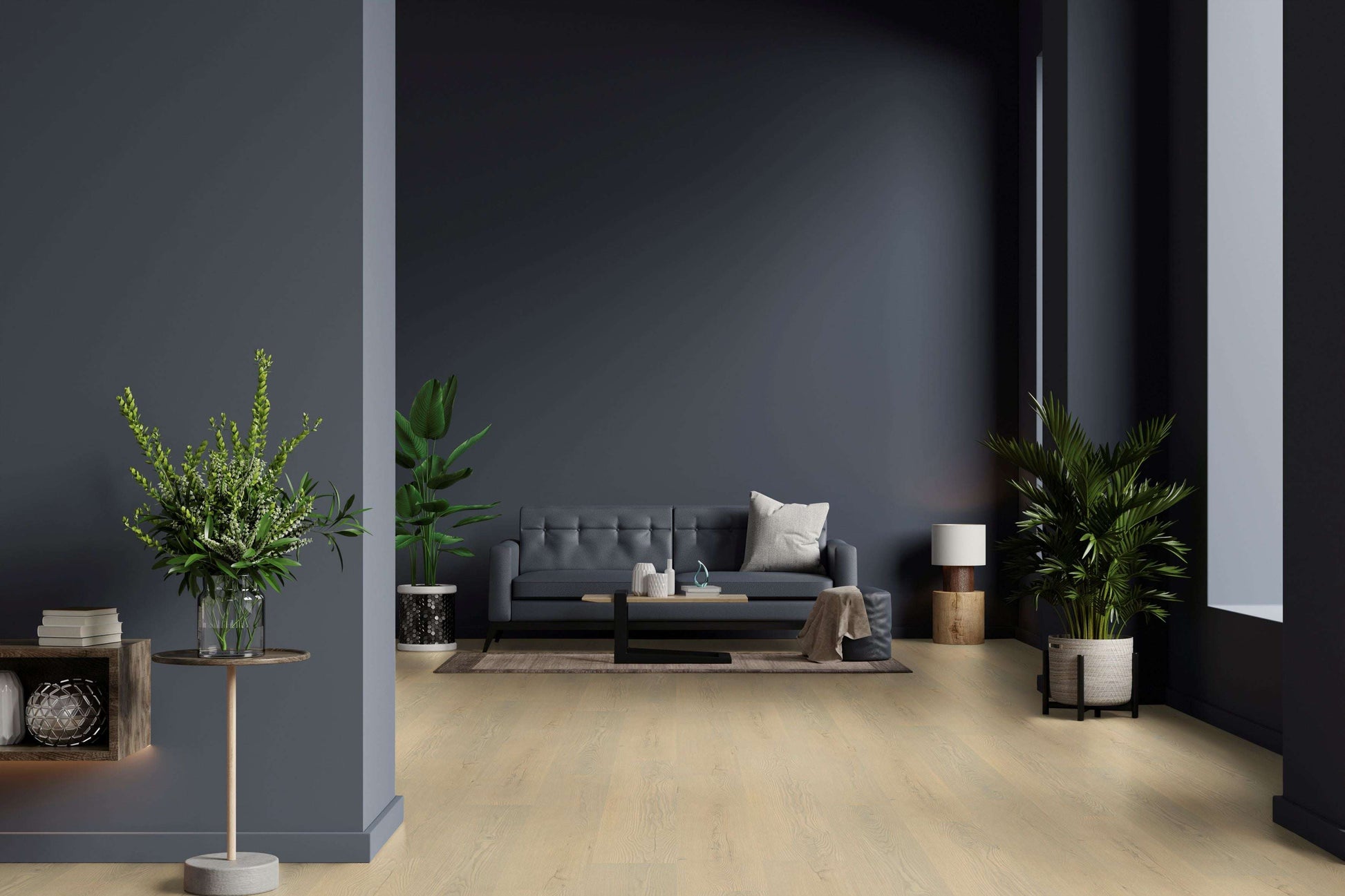 Modernes Wohnzimmer mit dunkelgrauer Couch, cremefarbenem Kissen, Couchtisch, Teppich, mehreren großen Zimmerpflanzen, Stehlampe, Beistelltisch mit Vase und Bücherregal an dunkelgrauer Wand, heller Holzboden.