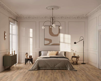 Schlafzimmer mit großem Bett, grauer Decke, mehreren Kissen, modernem Kronleuchter, abstraktem Wandbild, Nachttischen, Stehlampe, Kommode, Holzfußboden, Fenster mit weißen Gardinen, Stuckornamenten an Decke.