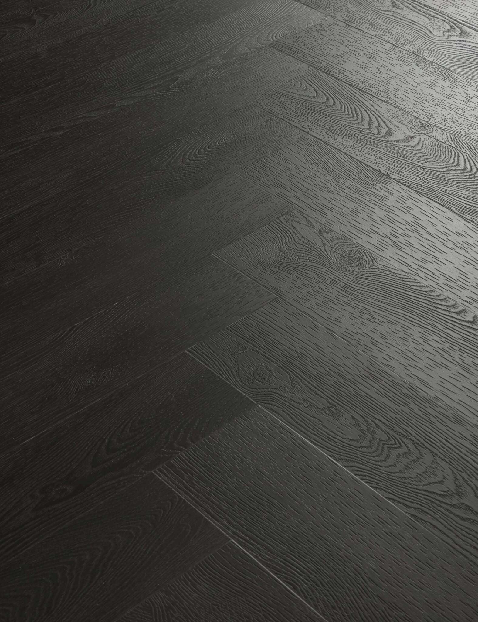 Dunkler Holzboden mit sichtbarer, strukturierter Maserung, angeordnet im Fischgrätmuster, mehrere gleichmäßige Paneele