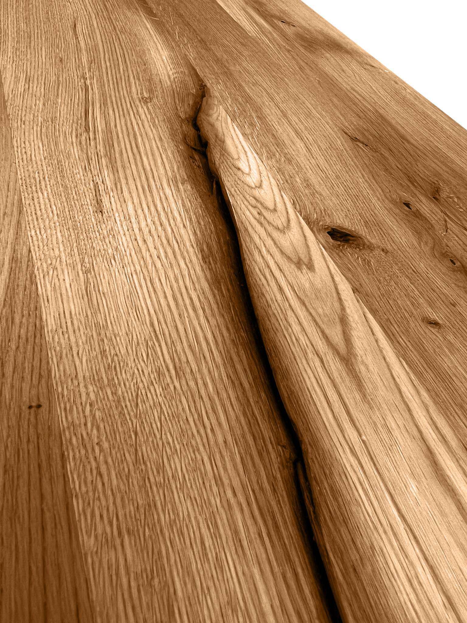 Holzoberfläche aus massiver Wildeiche mit natürlicher Maserung, Astlöchern und einer charakteristischen Rissstruktur. Die Maserung verläuft längs über die gesamte Fläche, und der Farbton ist warm und leicht golden. In der Mitte befindet sich ein auffälliger, tiefer Riss, der dem Holz ein rustikales Aussehen verleiht. Das Holz wirkt unbehandelt oder nur leicht geölt, wodurch die natürlichen Details und die Textur klar sichtbar bleiben.